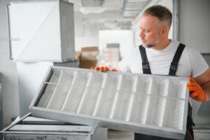 rsz a male worker holds an air filter for air conditio utc copy